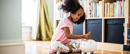 Child filling piggy bank