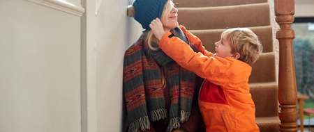 Child pulling hat down over womans eyes