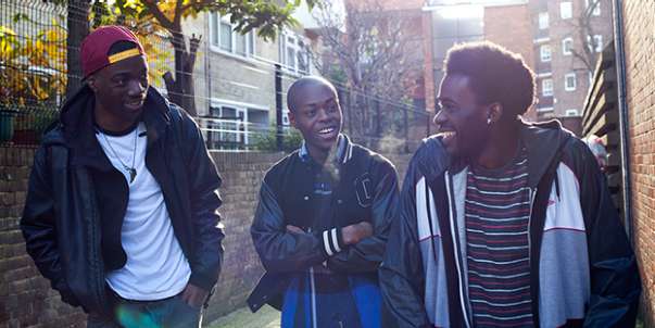 Three men walking, smiling